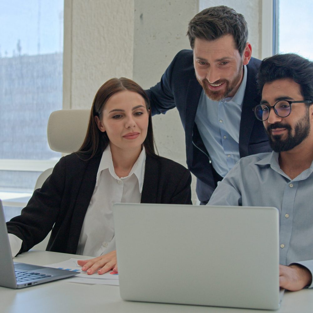 Three happy business people creative team coworkers smiling businessmen businesswoman working together at office company discussing project results mentor teaching office trainees teamwork cooperation. High quality 4k footage